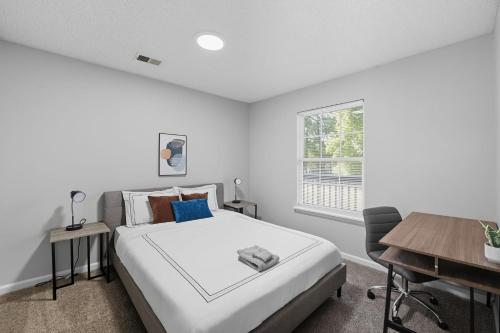 Un dormitorio con una cama y un escritorio y una ventana. en Near Fort Liberty Modern 1br I Free Parking I Gym, en Spring Lake