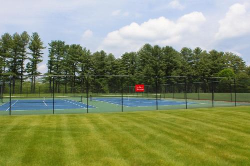 a tennis court with two tennis courts at The Ponds at Foxhollow in Lenox
