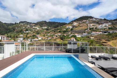 a swimming pool on the roof of a house at Madeira Ocean View Pool and Comfort in Caniço in Caniço