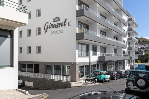 a white building with a car parked in front of it at Madeira Ocean View Pool and Comfort in Caniço in Caniço