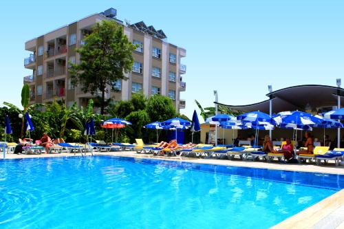 ein Pool mit Stühlen und Sonnenschirmen sowie ein Hotel in der Unterkunft Perle Apart Hotel in Alanya