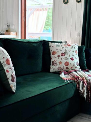 a green couch with two pillows on it at Hajerówka in Lubliniec