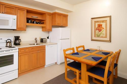 a kitchen with a table and a white refrigerator at The Ponds at Foxhollow in Lenox