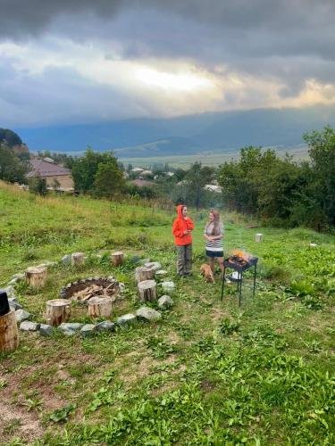 two people standing next to a fire pit in a field at Dez Guest House, Margahovit, Lori in Margahovit