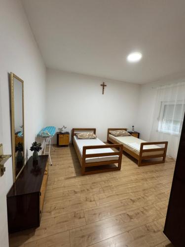 a room with two beds and a cross on the wall at Kuća za odmor Nikola Medjugorje in Čitluk