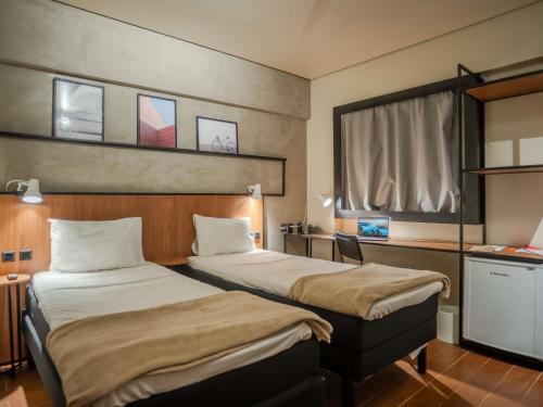 a hotel room with two beds and a window at ibis Sao Luis in São Luís