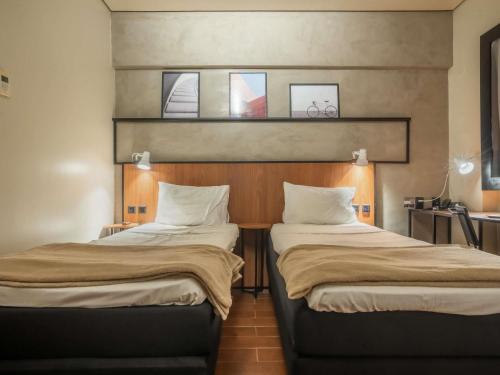 two beds sitting next to each other in a room at ibis Sao Luis in São Luís