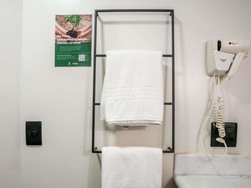 a towel rack in a bathroom with white towels at ibis Sao Luis in São Luís