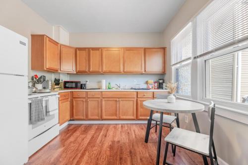 a kitchen with wooden cabinets and a table with chairs at Cozy Little Italy Apt Fast Wifi Pet Friendly in Cleveland