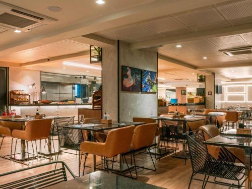 a restaurant with tables and chairs in a room at ibis Sao Luis in São Luís