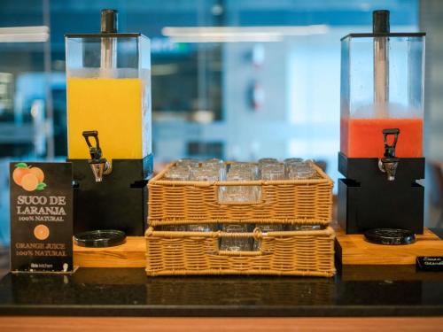 a table with two glasses of juice and a basket at ibis Sao Luis in São Luís