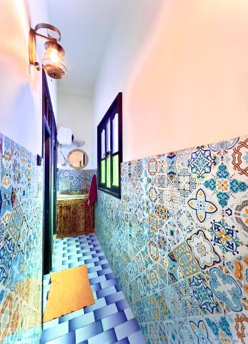 a hallway with colorful tiles on the walls at Riad Dar Sahara - Panoramic Rooftop in Nkob