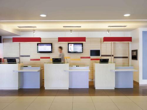 a person standing at a counter in an office at Ibis Hermosillo in Hermosillo