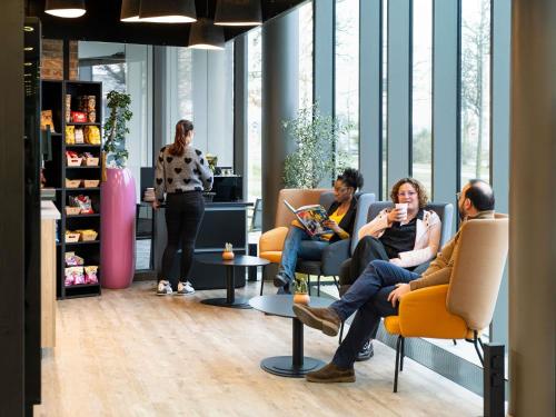 a group of people sitting in chairs in a room at Novotel Suites Luxembourg in Luxembourg