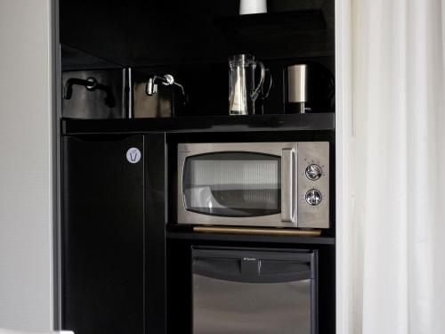 a microwave in a black cabinet with a window at Novotel Suites Luxembourg in Luxembourg