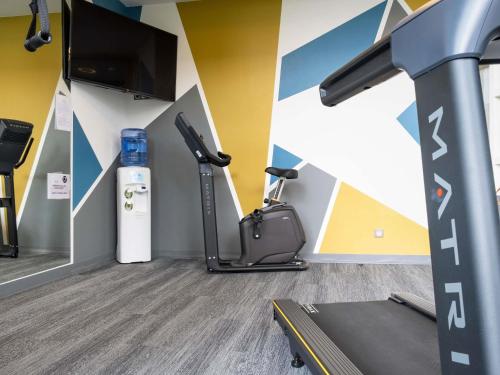 a gym with a treadmill and a flat screen tv at Novotel Suites Luxembourg in Luxembourg