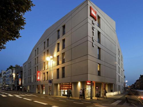 a building on a street with people walking in front of it at ibis Sint Niklaas Centrum in Sint-Niklaas
