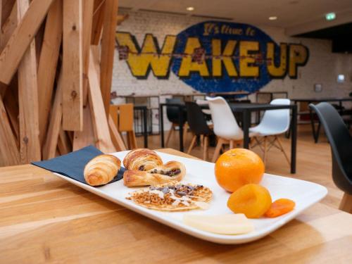 a plate of pastries and oranges on a table at ibis Styles Calais Centre in Calais