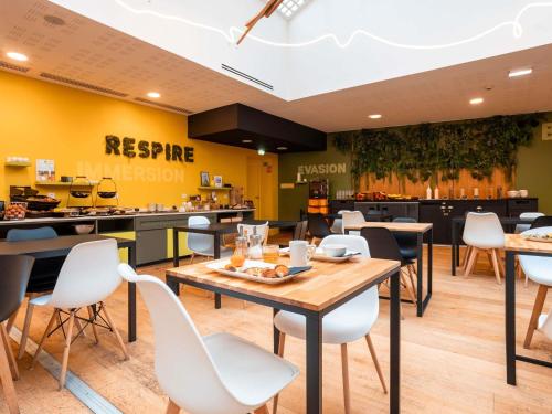 a restaurant with a table and chairs and a counter at ibis Styles Calais Centre in Calais