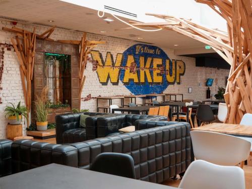 a restaurant with leather furniture and a sign that says wave wake up at ibis Styles Calais Centre in Calais