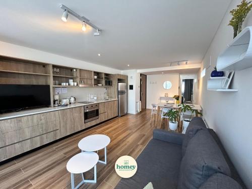 a living room with a couch and a kitchen at HOMEY Departamentos in Mar del Plata