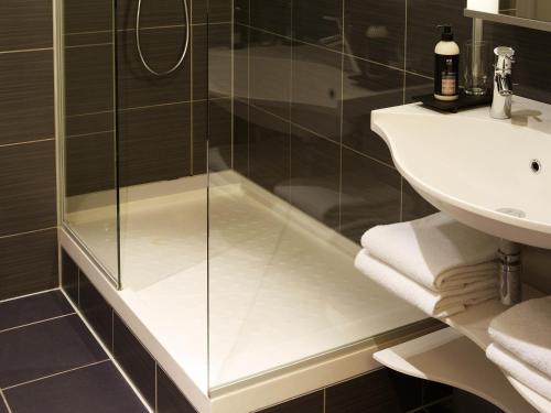a bathroom with a shower and a sink at Aparthotel Adagio Vienna City in Vienna