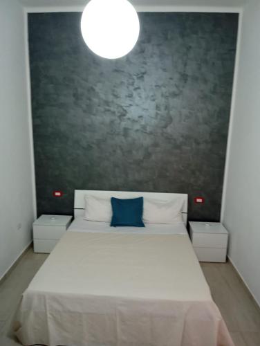 a bedroom with a large white bed with a blue pillow at Casa Letizia in Bernalda