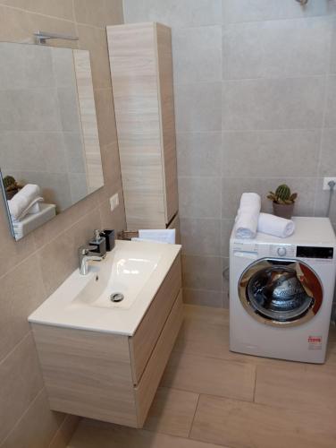 a bathroom with a washing machine and a sink at Casa Letizia in Bernalda