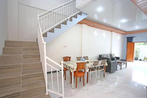 a dining room with a staircase and a table and chairs at Mentari Homestay in Sentool