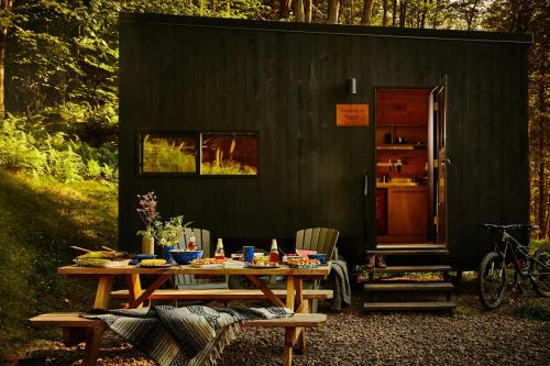 a picnic table in front of a black shed at Postcard Cabins Big Bear in Running Springs