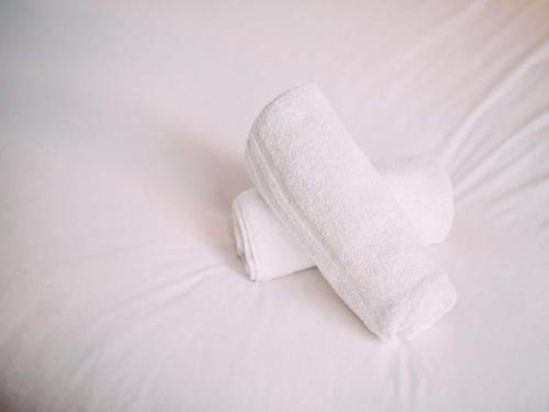 a roll of white toilet paper sitting on a bed at ibis Belfast City Centre in Belfast
