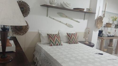 a bedroom with a bed with two pillows on it at Charming and comfortable Kitnet in Marataizes