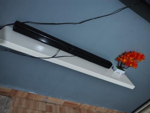 a black light on a table with a vase of flowers at LV Homes in Ongata Rongai 