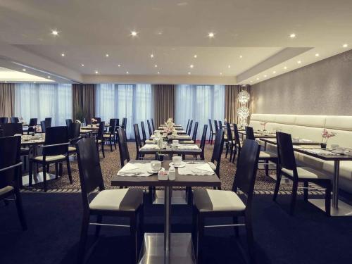 a dining room with tables and chairs in a room at Mercure Hotel Brussels Centre Midi in Brussels