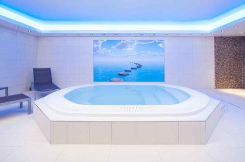 a large bath tub with a painting of the ocean at Mercure Hotel Brussels Centre Midi in Brussels