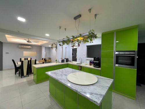 a kitchen with green cabinets and a counter top at 5-15pax Ampang Homestay 5BR House Near KLCC in Ampang