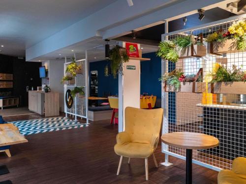 a room with a table and chairs and plants on the wall at ibis Lille Lomme Centre in Lomme