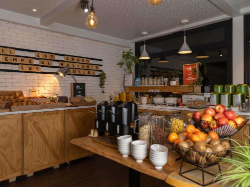 a kitchen with baskets of fruit on a table at ibis Lille Lomme Centre in Lomme