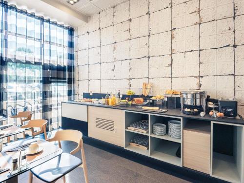 a kitchen with a counter with food on it at Hôtel Mercure Thionville Centre Porte du Luxembourg in Thionville