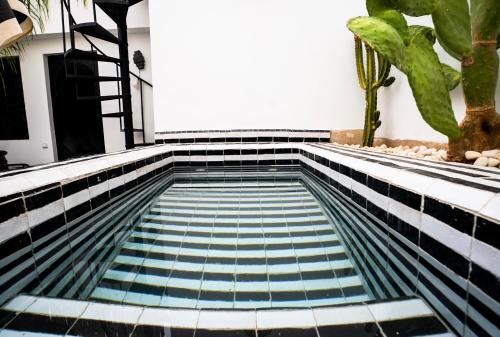 a swimming pool with blue and black tiles at Riad SASHA Exclusive&New Pool 6 pax Free Breakfast in Marrakech