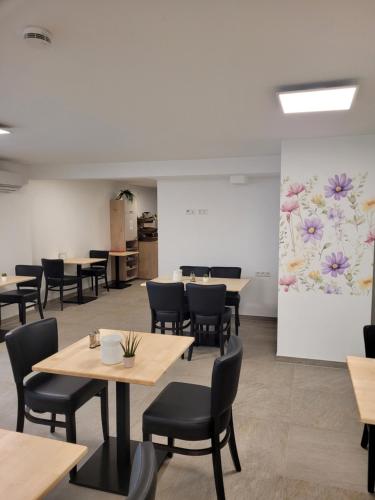 a room with tables and chairs and a wall with flowers at Rana's B&B - Bed&Breakfast in Rust