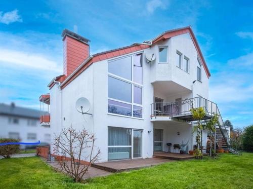a white house with a red roof at Gästehaus Virtuous Home in Pirmasens