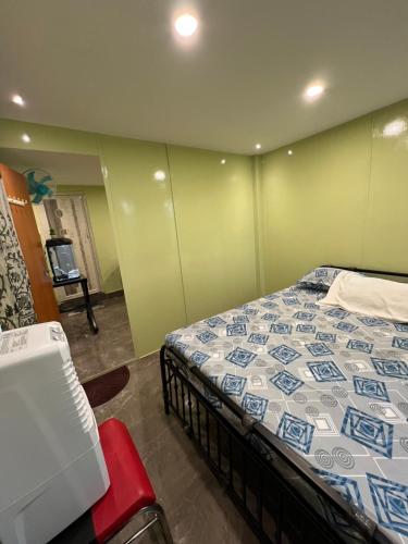 a bedroom with a bed in a room with green walls at 2BHK-Cozy Private Homestay- Near Bangalore International Exhibition Centre-BIEC in Bengaluru