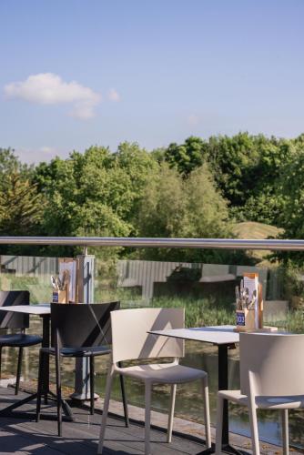 a row of tables and chairs sitting on a balcony at The Copthorne Hotel Cardiff in Cardiff