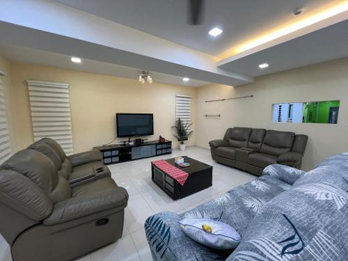a living room with couches and a flat screen tv at 5-15pax Ampang Homestay 5BR House Near KLCC in Ampang