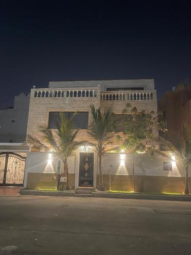 a building with palm trees in front of it at night at Elegant Studio in Jeddah