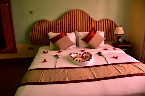 a bed with a bowl of flowers on it at Breeze Hotel Nyahururu in Nyahururu