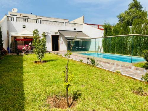 a house with a yard with a swimming pool at Belle maison avec piscine à 7 min de la plage en voiture in Dar Bouazza