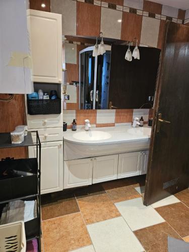 a bathroom with a sink and a large mirror at Izi Apartman in Husain