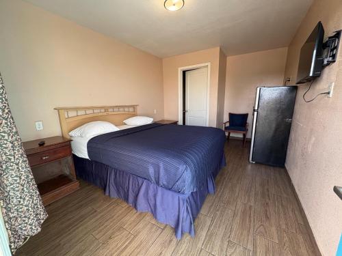 a bedroom with a bed and a refrigerator in it at SE'Air Motel By Townhouse Corpus Christi - Padre Island Tx in Corpus Christi